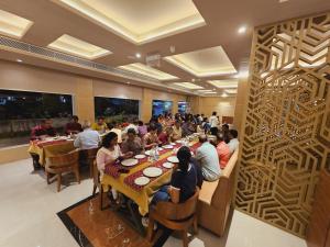 a group of people sitting at tables in a restaurant at Utham Mahal in Anchal