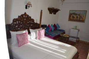 a bedroom with a large bed with pink and purple pillows at Dar Meziana in Chefchaouen