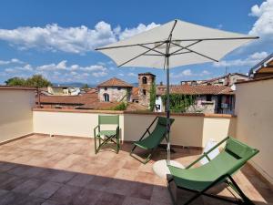 a patio with two chairs and an umbrella at Private suite 82 in Lucca