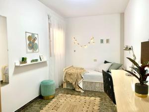 a small bedroom with a bed and a table at Your Holiday Home - El Tablado - Tenerife Sur in El Escobonal