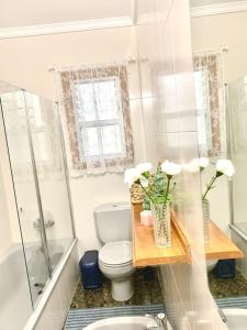 a white bathroom with a toilet and a sink at Your Holiday Home - El Tablado - Tenerife Sur in El Escobonal
