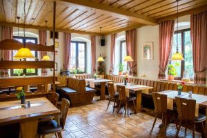 a restaurant with wooden tables and chairs and windows at Hotel zur Linde in Gädheim