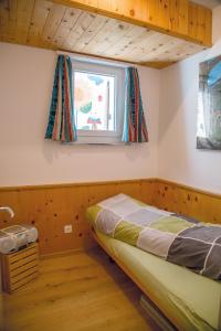 a bedroom with a bed and a window at Familienwohnung Epomeo Surlej in Surlej