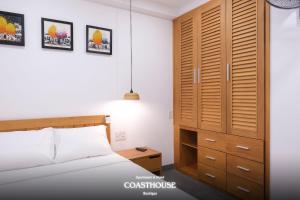 a bedroom with a bed and a wooden cabinet at Coast House Boutique Hotel in Nha Trang