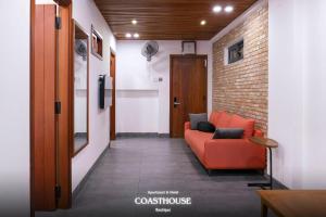 a living room with a red couch and a brick wall at Coast House Boutique Hotel in Nha Trang