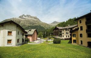 a village with buildings and a mountain in the background at Familienwohnung Epomeo Surlej in Surlej