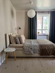 une chambre avec un lit, une fenêtre et une table dans l'établissement Tunnelmallinen yksiö kaupungin läheisyydessä, à Lahti
