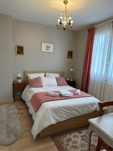 a bedroom with a large bed with a chandelier at Maison Grand Paris avec jardin et parking privé proche RER B et M14 in Arcueil