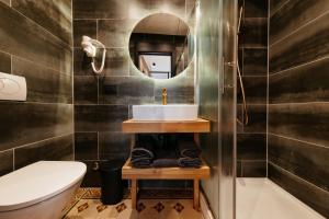 a bathroom with a sink and a toilet and a mirror at Main Square Rooms in Maribor