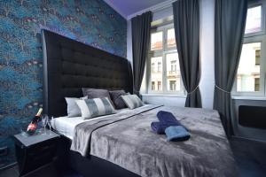 a bedroom with a large bed with a blue wall at TF Wellness in Prague