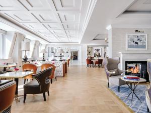 a living room with chairs and a fireplace at The Langham London in London