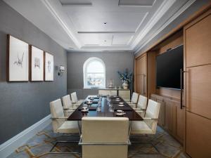 een vergaderzaal met een lange tafel en stoelen bij The Langham London in Londen