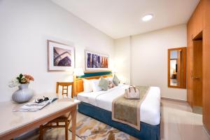 a hotel room with a bed and a desk at Golden Sands Hotel Apartments in Dubai