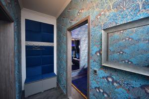 a hallway with a mirror and blue wallpaper at TF Wellness in Prague