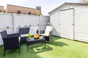 a patio with chairs and a table on grass at Open Mind Property - 4 Beds 2 Bathrooms & Parking in Portsmouth