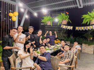 a group of people posing for a picture at a restaurant at Coast House Boutique Hotel in Nha Trang