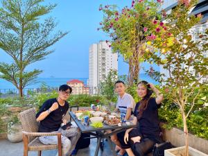 a group of people sitting at a table eating food at Coast House Boutique Hotel in Nha Trang