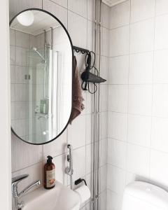 une salle de bain avec un miroir et un lavabo dans l'établissement Tunnelmallinen yksiö kaupungin läheisyydessä, à Lahti