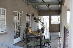 Un patio con una mesa y sillas en un porche. en Tucked-Away 1&2 Bedroom Houses, en Nelspruit 37 fotos más