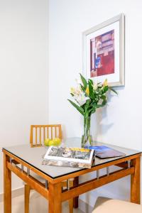 a dining room table with a vase of flowers at Golden Sands Hotel Apartments in Dubai