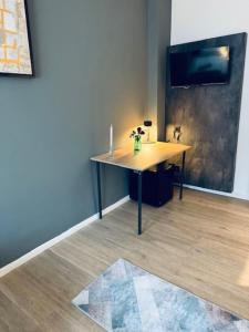 a desk in a room with a table with flowers on it at Hotel Charlton in Hannover +60 photos