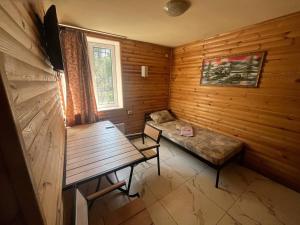 a room with a bench and a table in a wooden room at PitStop Motel in Kamianske