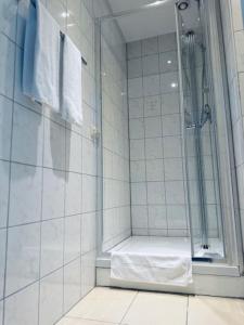a bathroom with a shower with a bench in it at Hotel Charlton in Hannover