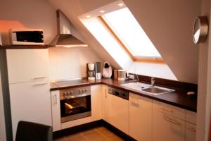 a kitchen with a stove and a sink and a window at Sonnenschein 29 - Großenbrode in Grossenbrode