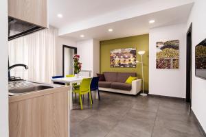 a kitchen and living room with a couch and a table at Residence Palazzo dei Delfini by RECEPTIO in Catania