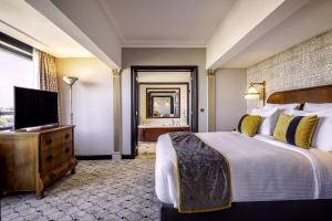 a hotel room with a bed and a television at Hotel Barsey by Warwick in Brussels