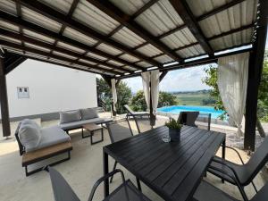 a patio with a table and chairs and a pool at Holiday Home Nirvana in Gornji Mihaljevec