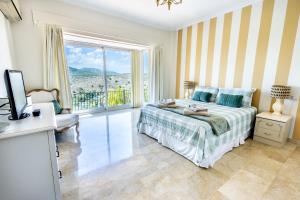 阿尔豪林格朗德Stunning Golf Villa with Pool and Stunning Views的一间卧室，里面有一张床和一扇大窗户。