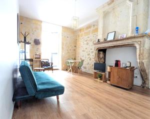 a living room with a couch and a fireplace at B&B Bordeaux Saint Michel in Bordeaux