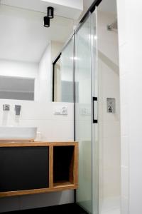a bathroom with a sink and a glass shower at Katedralnie w Apartamenty Gorzów in Gorzów Wielkopolski