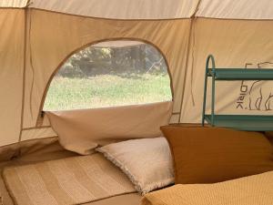 a tent with a window and a pillow in it at Partifecske kemping in Pilismarót