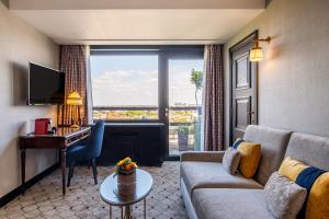a living room with a couch and a desk at Hotel Barsey by Warwick in Brussels