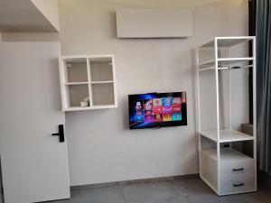 a flat screen tv hanging on a white wall at Rooftop one room غرفه نوم فقط in Amman