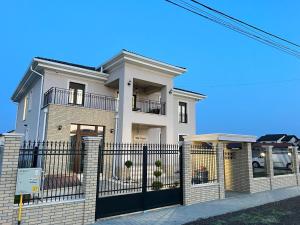Moşniţa NouăPensiunea Villa D'Amici的一座带黑色围栏的大型白色房屋