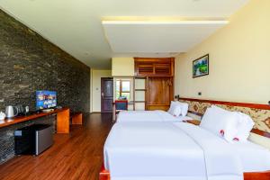 a hotel room with two beds and a tv at Lisha Garden Resort Hotel in Vang Vieng +59 photos
