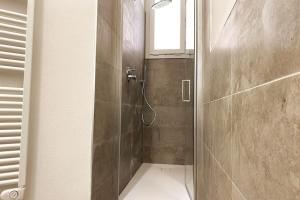 une douche avec une porte en verre dans une salle de bain dans l'établissement Reno Apartment, à Casalecchio di Reno 14 autres photos