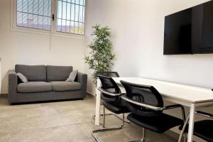 un salon avec une table, des chaises et un canapé dans l'établissement Reno Apartment, à Casalecchio di Reno