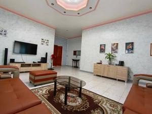 a living room with a couch and a tv at Blue Gates Paradise in Dipolog
