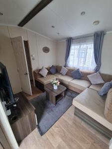 a living room with a couch and a tv at 163 Holiday Resort Unity Brean sands Pet friendly in Berrow