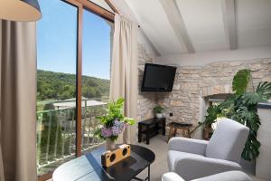 a living room with a large window and a tv at Villa Stanza Campitelli for up to 21 people in Central Istria with private pool and pet friendly in Bale