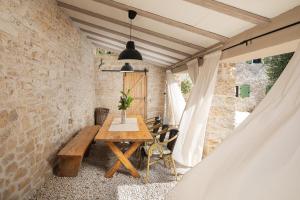 a dining room with a wooden table and a stone wall at Villa Stanza Campitelli for up to 21 people in Central Istria with private pool and pet friendly in Bale