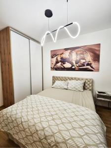 a bedroom with a bed and a chandelier at Moderan i stilski apartman - miran deo Novog Sada in Novi Sad