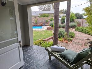 a porch with a chair and a view of a pool at 1 CAMDEBO in Oudtshoorn