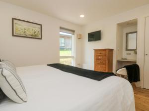 Un dormitorio con una gran cama blanca y una ventana. en Rowan, en Truro