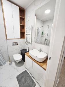a white bathroom with a sink and a toilet at Moderan i stilski apartman - miran deo Novog Sada in Novi Sad +40 photos