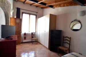 a living room with a television and a window at Via Toscana House in Parma